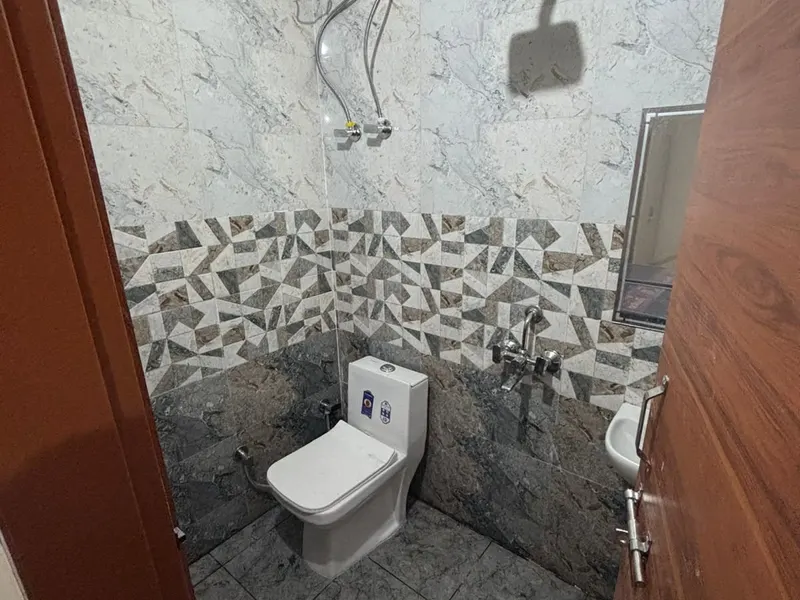 Bathroom with geyser and shower at the Gurugram location
