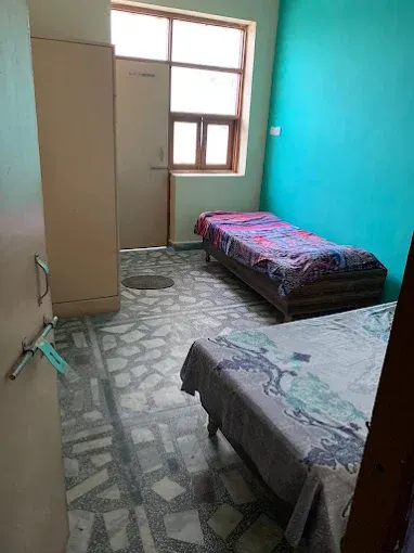 Double-sharing room with beds and cupboard at Yadav PG Dwarka